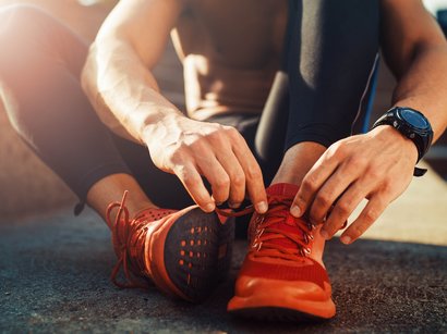 Laufstrecke Oberer Panoramaweg Jaufental Person bindet Laufschuhe an beim Training im Freien