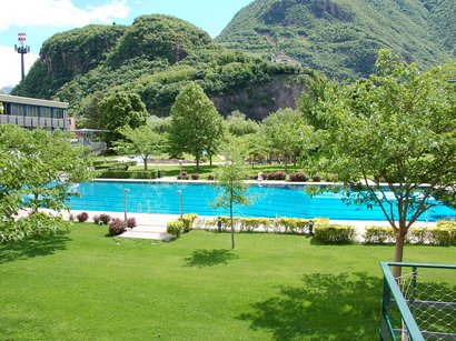 Hotel ad Appiano sulla Strada del Vino Piscina e prato verde davanti a montagne boscose sotto cielo azzurro
