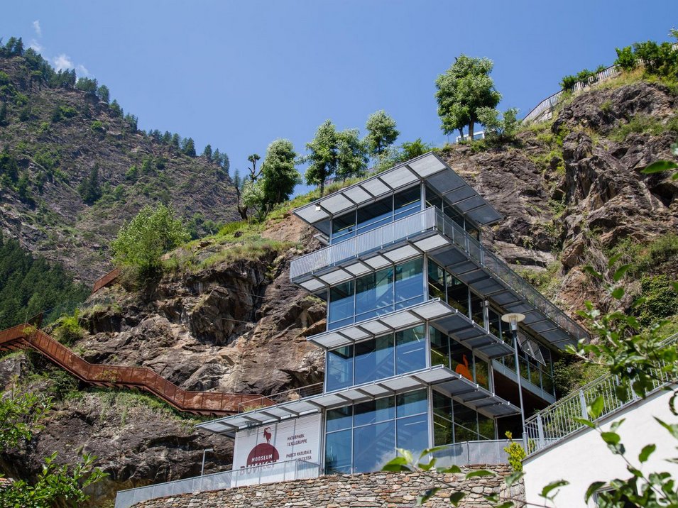 Il MuseoAltaPassiria di Moso in Passiria Centro visitatori moderno davanti a montagna rocciosa con cielo blu