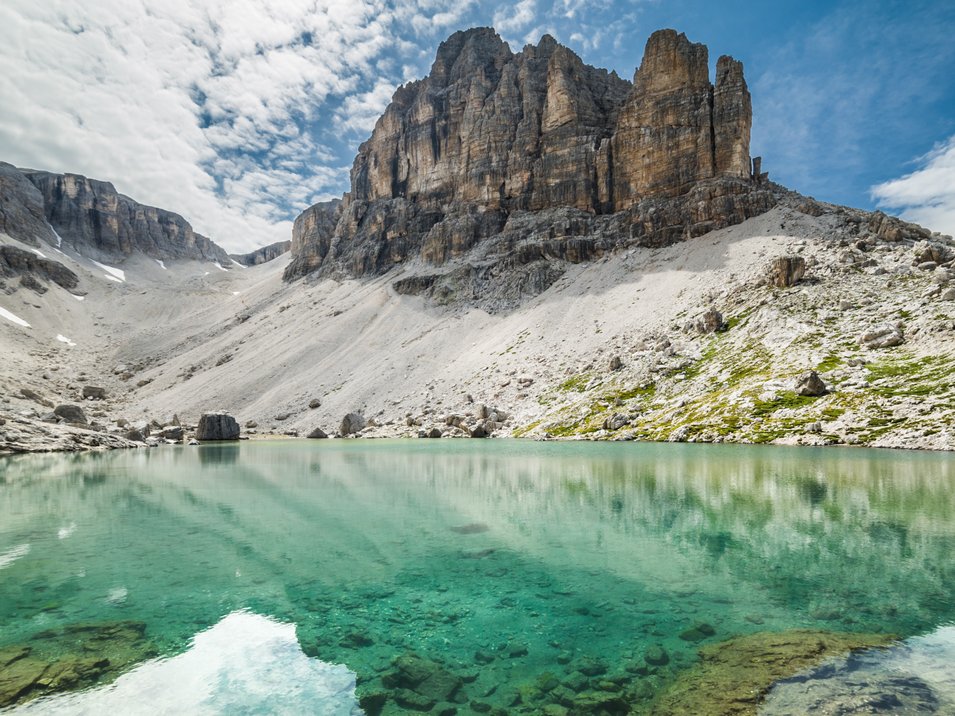 Der traumhafte Pisciadù-See in der Sellagruppe Klare türkisfarbene Bergsee mit Felsen und steilen Gipfeln unter bewölktem Himmel