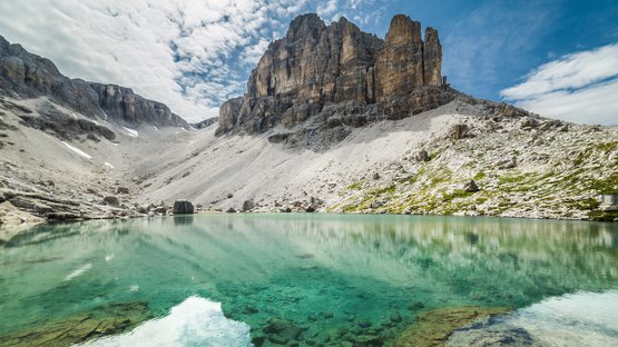 Der traumhafte Pisciadù-See in der Sellagruppe Klare türkisfarbene Bergsee mit Felsen und steilen Gipfeln unter bewölktem Himmel