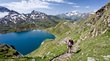 Großer Schwarzsee: legendenumrankter Bergsee in Südtirol Wanderer auf Bergpfad mit Blick auf See und schneebedeckte Berge