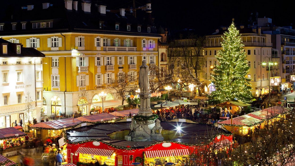 Il mercatino di Natale di Bolzano Mercato di Natale con albero illuminato e bancarelle in città di notte