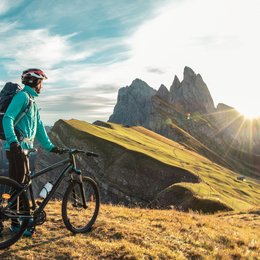 Pischadù-Klettersteig in Südtirol Radfahrer mit Helm schaut auf Bergpanorama bei Sonnenuntergang