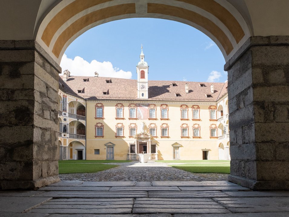 Diözesanmuseum Hofburg Brixen Innenhof eines historischen Gebäudes mit Arkaden und Uhrturm bei Sonnenschein