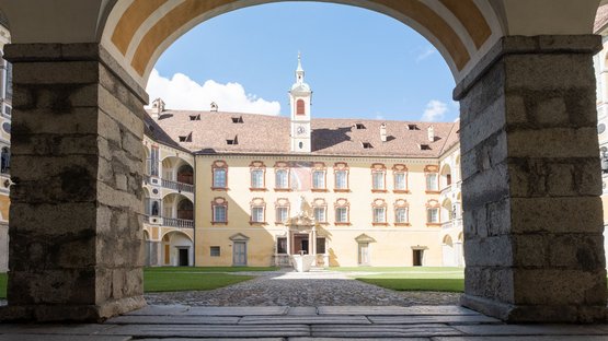Diözesanmuseum Hofburg Brixen Innenhof eines historischen Gebäudes mit Arkaden und Uhrturm bei Sonnenschein