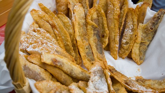 Cosa si mangia al Torggelen in Alto Adige? Cesto di dolci fritti italiani alle mandorle con zucchero a velo