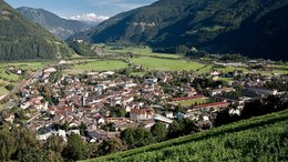 Hotels Eisacktal, Südtirol: Hotels in Brixen, Klausen … Blick auf eine Stadt im Tal umgeben von Bergen und grünen Wiesen bei klarem Himmel