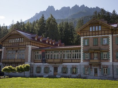 Hotel presso le Tre Cime di Lavaredo Edificio storico antico davanti a montagne boschive con cielo sereno