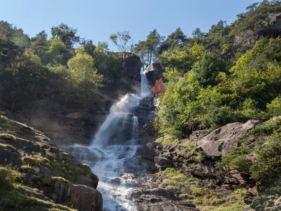 Barbianer Wasserfälle – erfrischendes Heilklima Wasserfall in einem bewaldeten, felsigen Gebirgsgebiet bei klarem Himmel