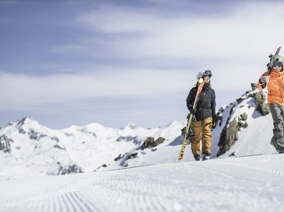 Das Skigebiet Kronplatz im Herzen der Dolomiten Zwei Skifahrer mit Ausrüstung auf schneebedecktem Berg bei klarem Himmel