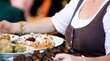 Bauernmärkte in Südtirol Frau trägt Teller mit verschiedenen traditionellen Speisen mit Puderzucker