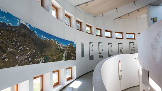 Centro visite Fanes-Senes-Braies Interno di un museo curvo con panorama montano e pannelli espositivi