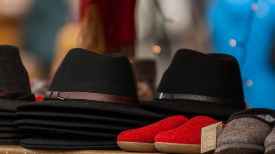 Mercatino di Natale di Bressanone Vari cappelli di feltro e pantofole su una bancarella del mercato
