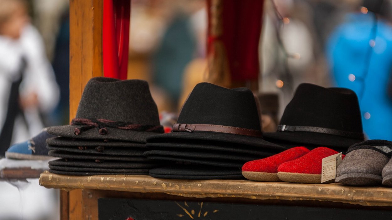 Mercati in Alto Adige Vari cappelli di feltro e pantofole su una bancarella del mercato