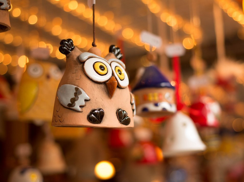 Il mercatino di Natale di Bolzano Figura di gufo in terracotta appesa davanti a uno sfondo sfocato con luci
