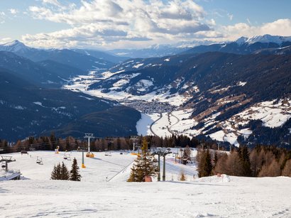 La Sellaronda, per girare attorno al massiccio del Sella Paesaggio montano innevato con impianto di risalita e valle sullo sfondo