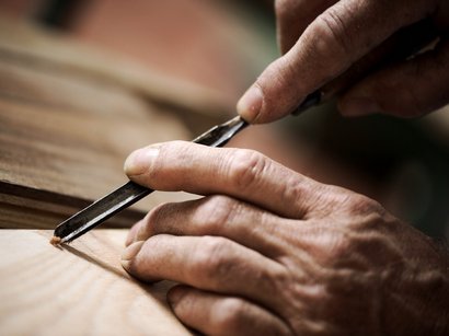 Etimologia del termine Törggelen Primo piano di mani che scolpiscono il legno con uno scalpello