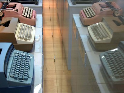 Hotel a Lana presso Merano Tre macchine da scrivere vintage blu, beige e rosa su un tavolo con riflesso