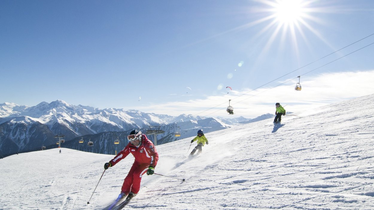 Schneespaß im Winterwunderland Watles Skifahrer fahren bei sonnigem Wetter auf schneebedecktem Berghang mit Sessellift