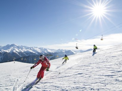 L’area sciistica di Solda all’Ortles Sciatori scendono su una pista innevata con il sole splendente e seggiovia