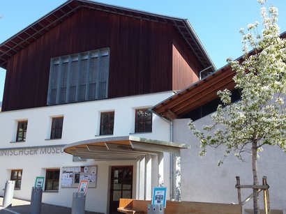 Hotel a Prato allo Stelvio Ingresso del museo con albero in fiore sotto cielo sereno