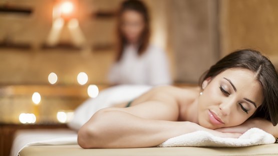 Hotel medical spa in Alto Adige Donna rilassata durante massaggio in ambiente spa con luce soffusa