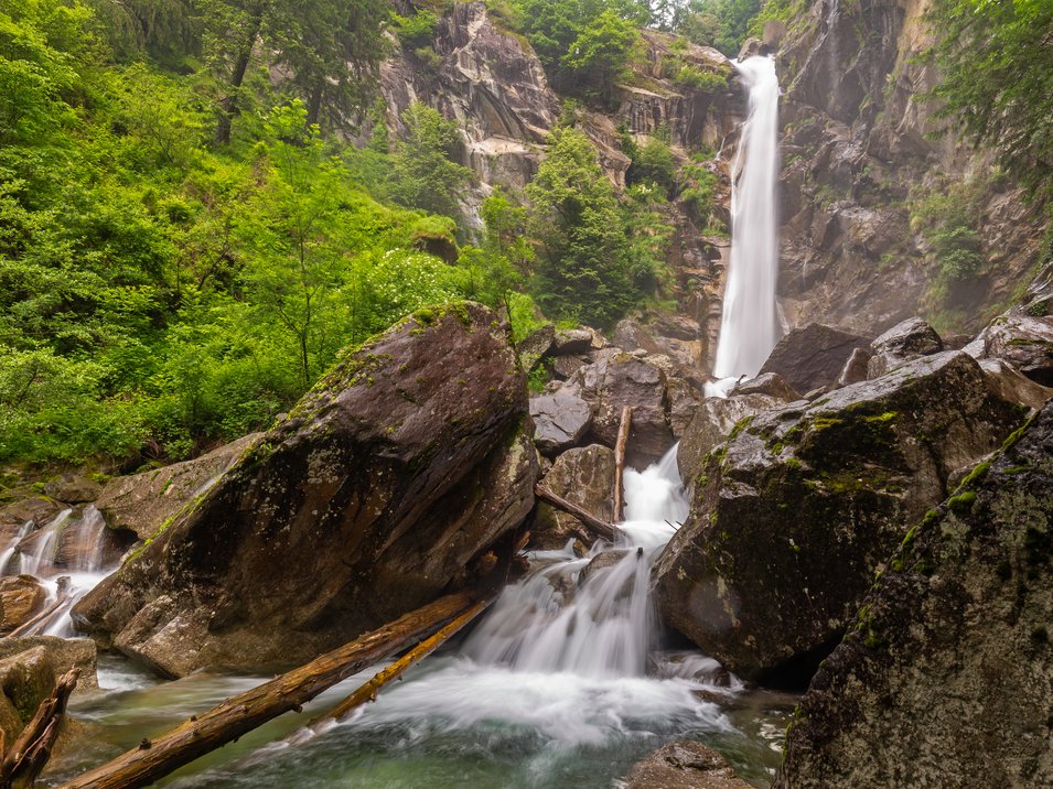 Südtirols Gewässer: Passeirer Wasserfall Wasserfall in grünem Wald mit großen Felsen und fließendem Bach