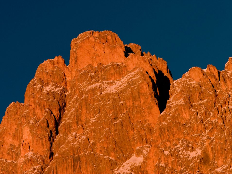 In cima al Catinaccio con la via ferrata Roda di Vael-Masarè Roccia illuminata dalla luce calda al tramonto sotto un cielo blu scuro