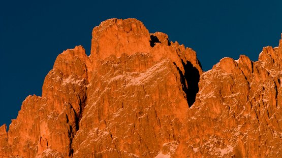 Klettern im Rosengarten: Rotwand- und Masarè-Klettersteig Felsen im warmen Abendlicht vor klarem dunkelblauem Himmel
