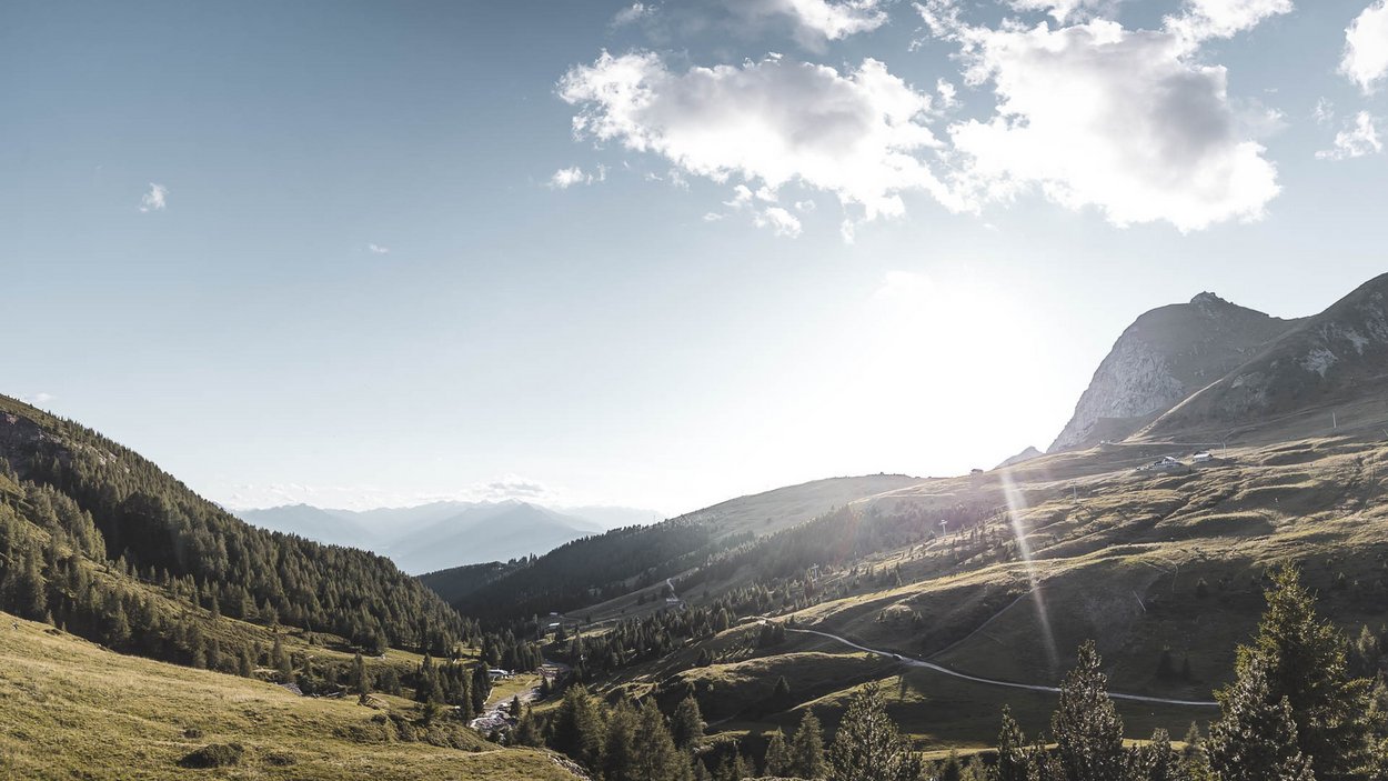 Golfclub Passiria.Merano Raggi di sole su una valle montuosa e boscosa con cielo sereno