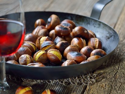 Etimologia del termine Törggelen Castagne arrostite in una padella con un bicchiere di vino rosso in primo piano