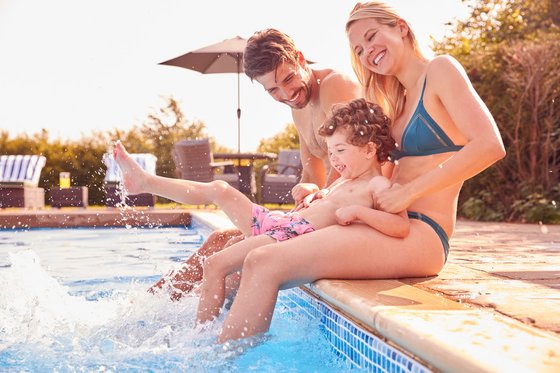 Hotels mit Pool in Südtirol Familie spielt und planscht am Pool mit lachendem Kind