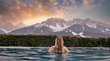 Cercasi hotel a 5 stelle in Alto Adige? Eccoli qui! Donna in piscina con vista sulle montagne innevate al tramonto