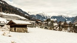 Ihre Hotels in Meran in Südtirol: Hotels im Meraner Land Schnee bedeckte Berglandschaft mit Häusern und Brücke im Winter