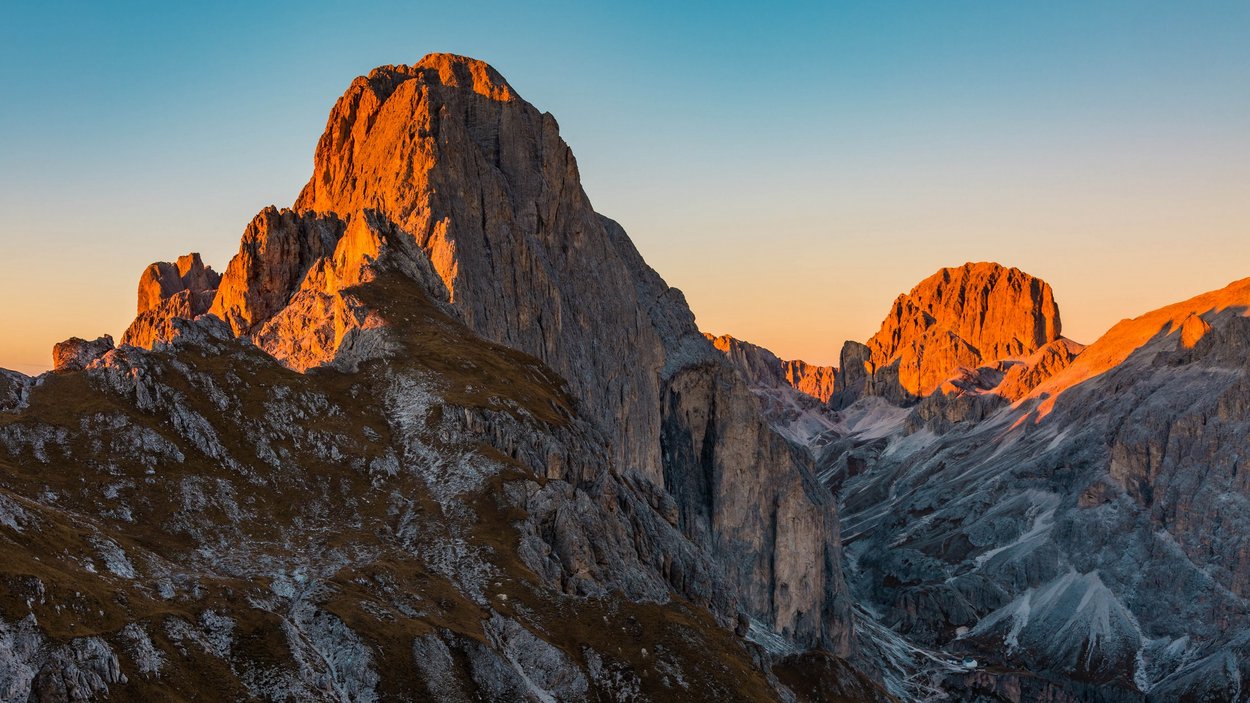 Hörspielwanderungen am Latemar Berggipfel in den Alpen bei Sonnenuntergang mit orangefarbenem Licht