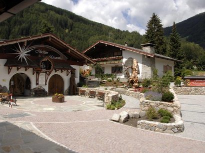 Hotel a Valdaora in Alta Pusteria Museo Maranatha con area esterna e montagne boschive sullo sfondo