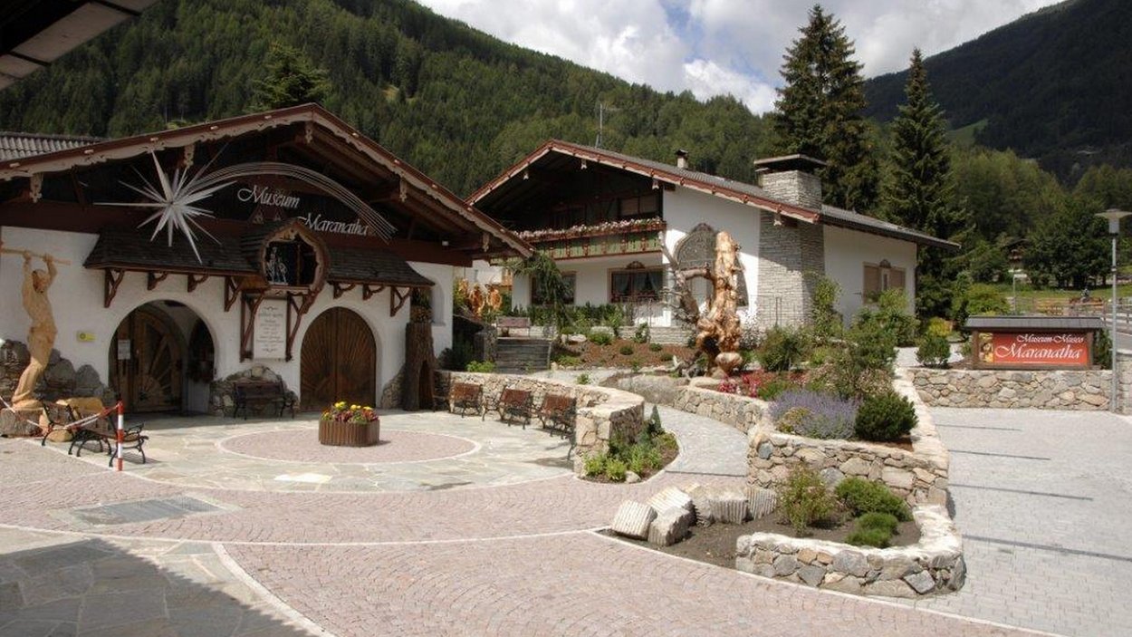 Das Krippenmuseum Maranatha Museum Maranatha und Umgebung vor bewaldeten Bergen