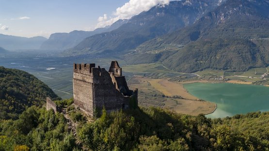 Castelchiaro a Caldaro Castello su collina boscosa con lago e montagne sullo sfondo