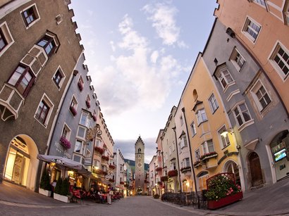 Der Weihnachtsmarkt in Klausen Bunte Häuser und Turmuhr in einer historischen Altstadtgasse