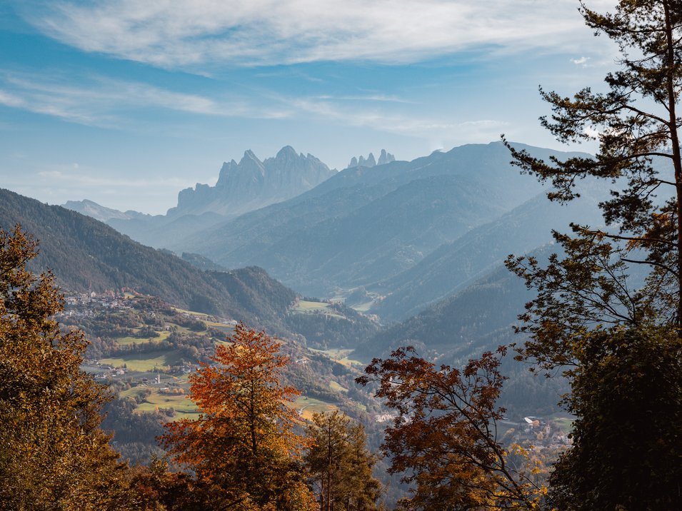 Roter Hahn - Schankbetriebe in Südtirol Herbstliche Berglandschaft mit bunten Bäumen und Nebel im Tal