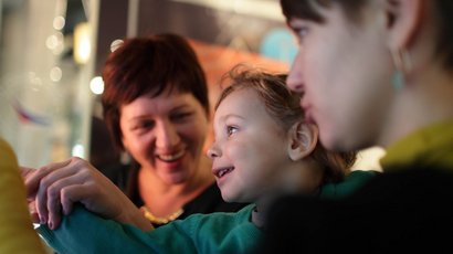 ArcheoParc in Val Senales Bambino sorridente tenuto affettuosamente da due donne