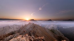 Hotels in Alta Badia: Urlaub durch und durch Sonnenaufgang über nebelverhangenen Berggipfeln in einem Gebirge