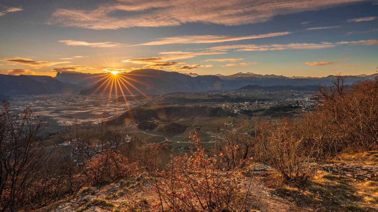 Hotel ad Appiano sulla Strada del Vino Alba su una valle con montagne e alberi autunnali in primo piano
