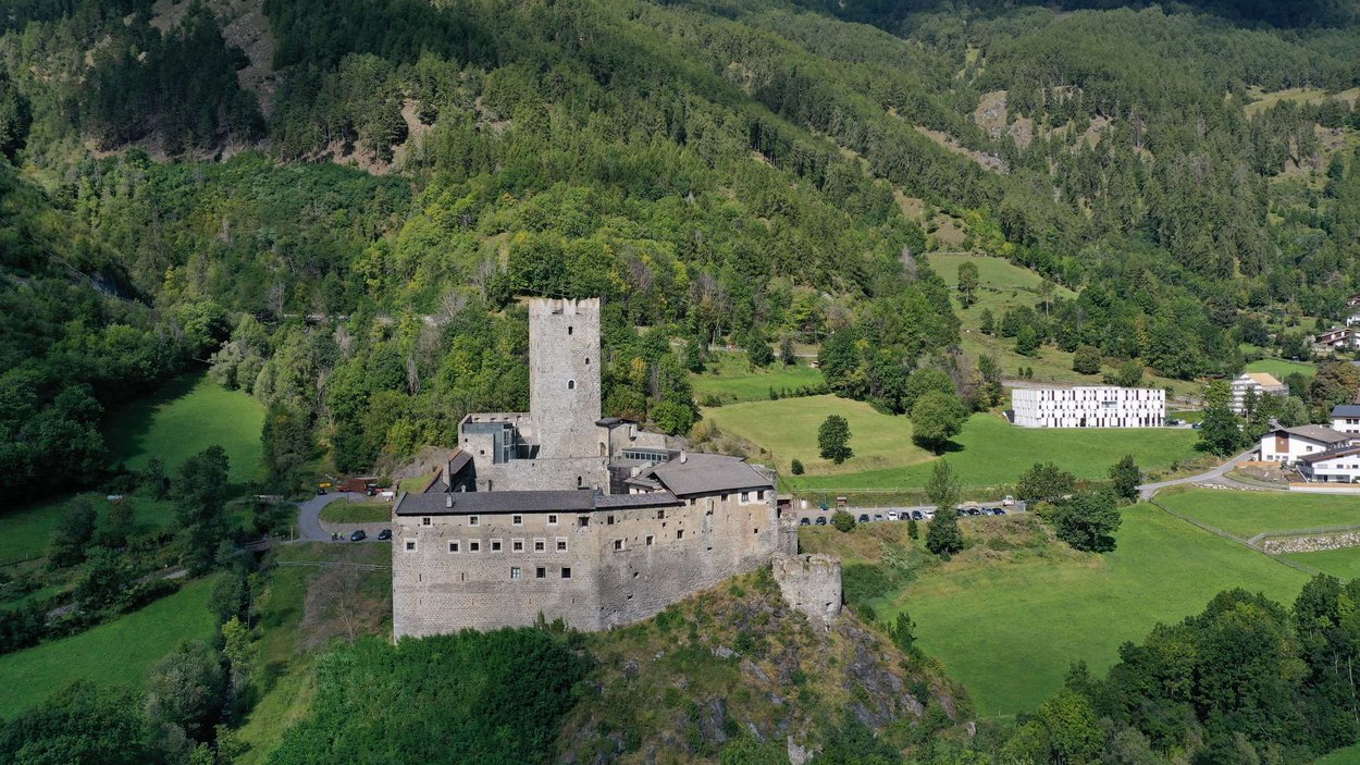 Die Fürstenburg bei Burgeis Burganlage auf einer grünen Anhöhe umgeben von Wald und Wiesen