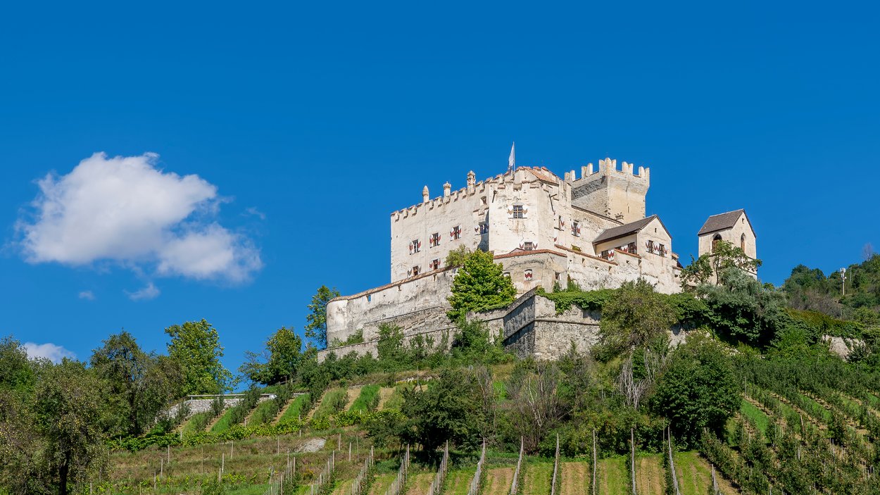 Castel Coira a Sluderno, in Val Venosta Castello storico su collina con vigneti e cielo azzurro