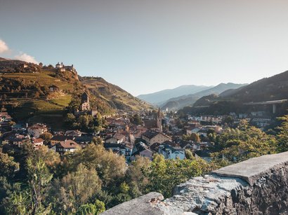 Hotel a Naz-Sciaves Vista di una città con montagne e castelli sullo sfondo sotto un cielo limpido