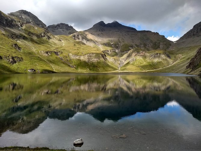 Die Natur in und um Südtirol Berglandschaft mit See und Spiegelung unter bewölktem Himmel