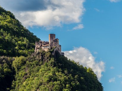 Castel Freudenstein ad Appiano Castello su collina verde con cielo azzurro e nuvole