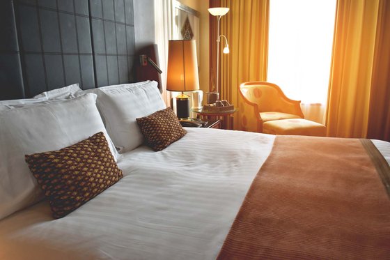 Ferienwohnungen mit Pool in Südtirol Gemütliches Hotelzimmer mit Doppelbett, Sitzsessel und warmem Licht